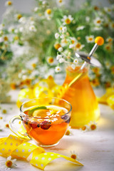 A healthy Cup of tea, a jar of honey and flowers. Selective focus.