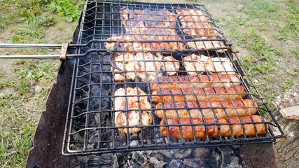 Cooking juicy and delicious pork, beef and chicken in the grill during summer vacation