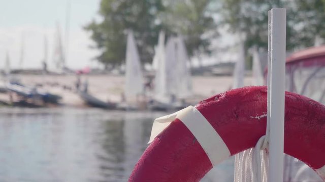 Lifebuoy is in focus and blur of yachts on shore behind