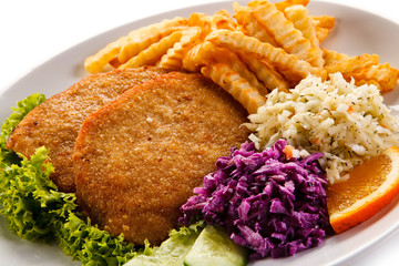 Fried pork chop, French fries and vegetables 