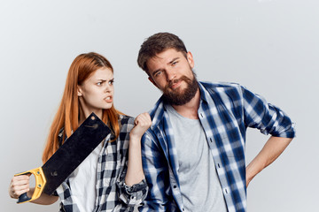Young beautiful woman and guy with beard on white isolated background, repair, building materials, tools