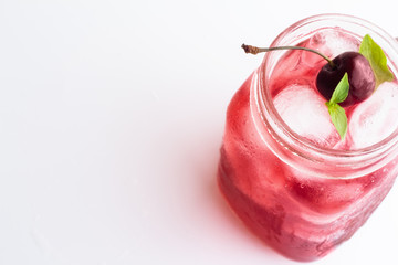 Red drink with ice and cherry on a white background top view. © ytochka89