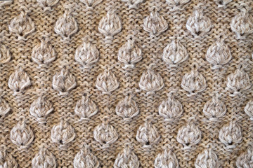 background texture of a knitted fabric with a raised pattern in the form of leaves close-up
