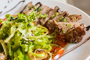 Warm salad with beef fried mushrooms tomanto and onion selective focus