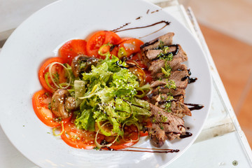 Warm salad with beef fried mushrooms tomanto and onion selective focus