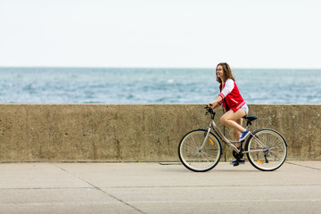 Fototapeta premium Urban biking - young woman riding bike 