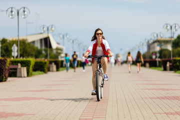 Urban biking - young woman riding bike 