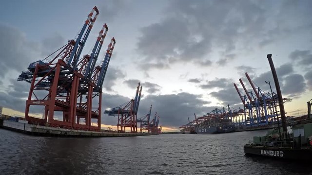 Hamburg / Germany - July 12 2017: Container gantry cranes of the terminal Eurogate unloading ships in the deepwater port Hamburg-Waltershof, time lapse