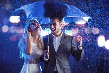Foto op Plexiglas Mode-stijl portret van een paar poseren in het regenachtige weer © konradbak