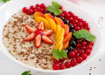 Tasty and healthy oatmeal porridge with berry, flax seeds and smoothies. Healthy breakfast. Fitness food. Proper nutrition