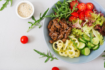 Salad with beef teriyaki and fresh vegetables - tomatoes, cucumbers, paprika, arugula and lettuce in bowl. Flat lay. Top view