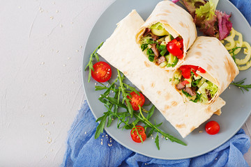 Shawarma from juicy beef, lettuce, tomatoes, cucumbers, paprika and onion in pita bread. Diet menu. Flat lay. Top view