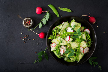 Fresh salad of cucumbers, radishes, green peas and herbs. Flat lay. Top view