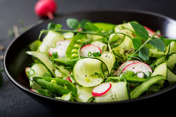 Fresh salad of cucumbers, radishes, green peas and herbs