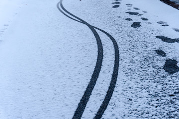 bicycle tracks and footprints on a path in winter with fresh snow