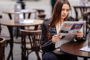 Fototapeta premium Girl sit at the table and read magazine