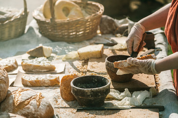 Female hands making sandwiches with spread and wholegrain bread outdoors in warm sunny day