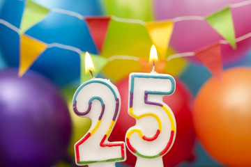 Happy Birthday number 25 celebration candle with colorful balloons and bunting