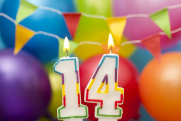 Happy Birthday number 14 celebration candle with colorful balloons and bunting
