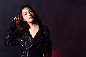 low key portrait of slim healthy woman in black background with fog smoke and light from back