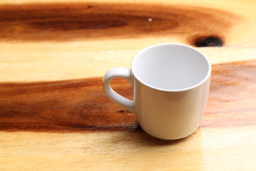 White cup on wood floor