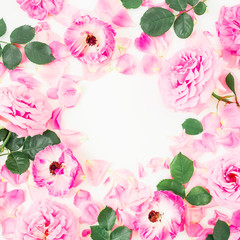 Round floral frame of pink rose flowers, leaves and petals on white background. Flat lay, top view.