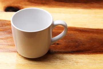 White cup on wood floor