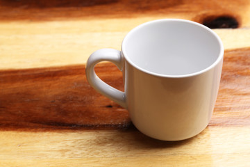 White cup on wood floor