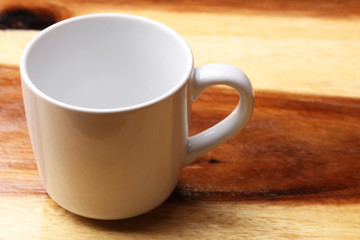 White cup on wood floor