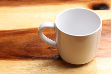 White cup on wood floor