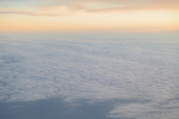 Fototapeta na wymiar flying above the clouds at sunset landscape from an airplane