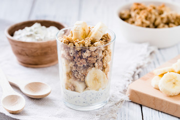 Chia pudding parfait, layered yogurt with banana, granola. Healthy breakfast