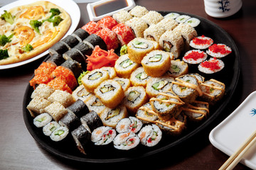 Sushi and rolls on a wooden table.