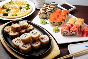 Sushi and rolls on a wooden table.