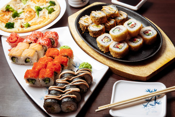 Sushi and rolls on a wooden table.