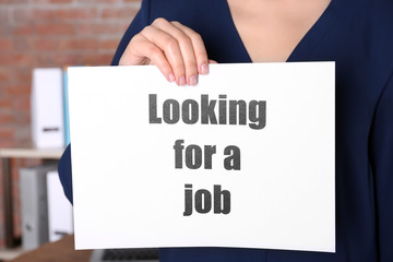 Woman holding paper sheet with text LOOKING FOR A JOB. Marketing concept