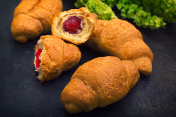Croissants with raspberry jam. Dark blue background. Close-up. Top view