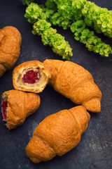 Croissants with raspberry jam. Dark blue background. Close-up. Top view