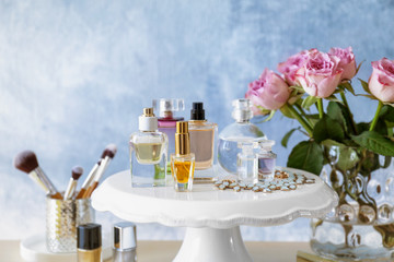Stand with bottles of perfume on table