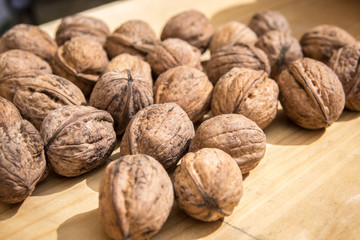 Walnuts on a wooden table. Many nuts without breaking the shell. Walnuts close up.