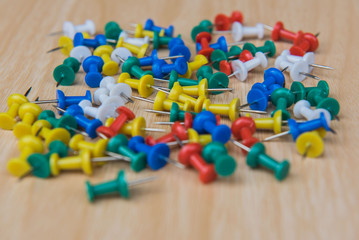 Many colorful pile pin on a wood  background.