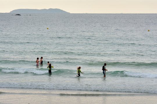 Des gens vont prendre un bain de mer sur une plage en Bretagne
