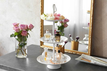 Stand with bottles of perfume on table