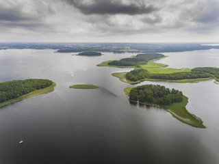 Aerial view of green islands and clouds at summer sunny morning. Masurian Lake District  in Poland.