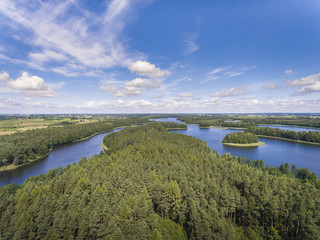 Aerial view of green islands and clouds at summer sunny day.Wydminy lake on Masuria in Poland.