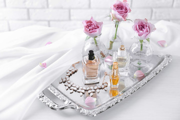 Obraz na płótnie Canvas Metal tray with bottles of perfume on table