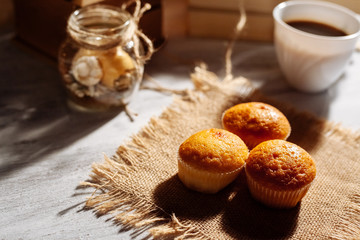Muffins and coffee on a wooden table.