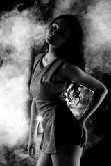 low key portrait of slim healthy woman in black background with fog and light from back, sexy pose s curve with short pants and shadow, black and white concept