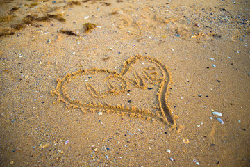 Fototapeta na wymiar Heart drawn in the sand on the beach