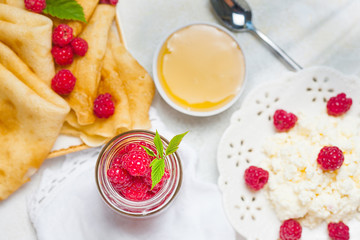 Homemade pancakes with honey, raspberries, cottage cheese with powder sugar. Flat lay, top view. copy space. eco style